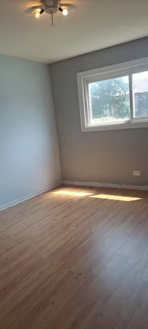 a view of a room with wooden floor and a window