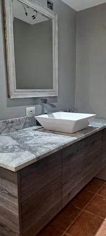 a bathroom with a granite countertop sink and a mirror