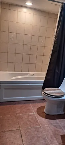 a bathroom with a toilet and a shower
