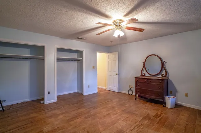 an empty room with closet and wooden floor