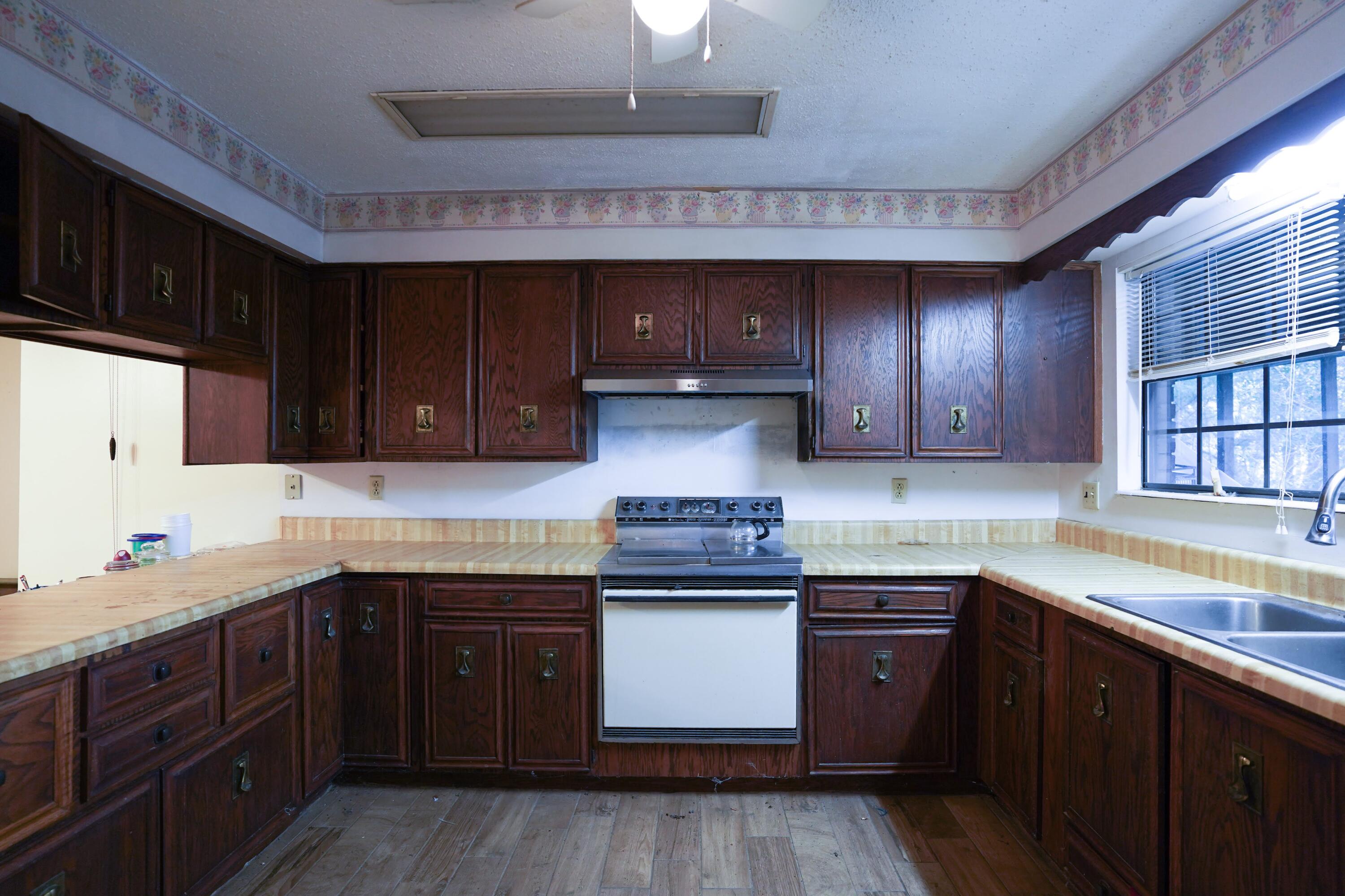4444 Sundance Way Holt, FL 32564 - Photo 22 of 39 a kitchen with stainless steel appliances granite countertop wooden cabinets and a sink