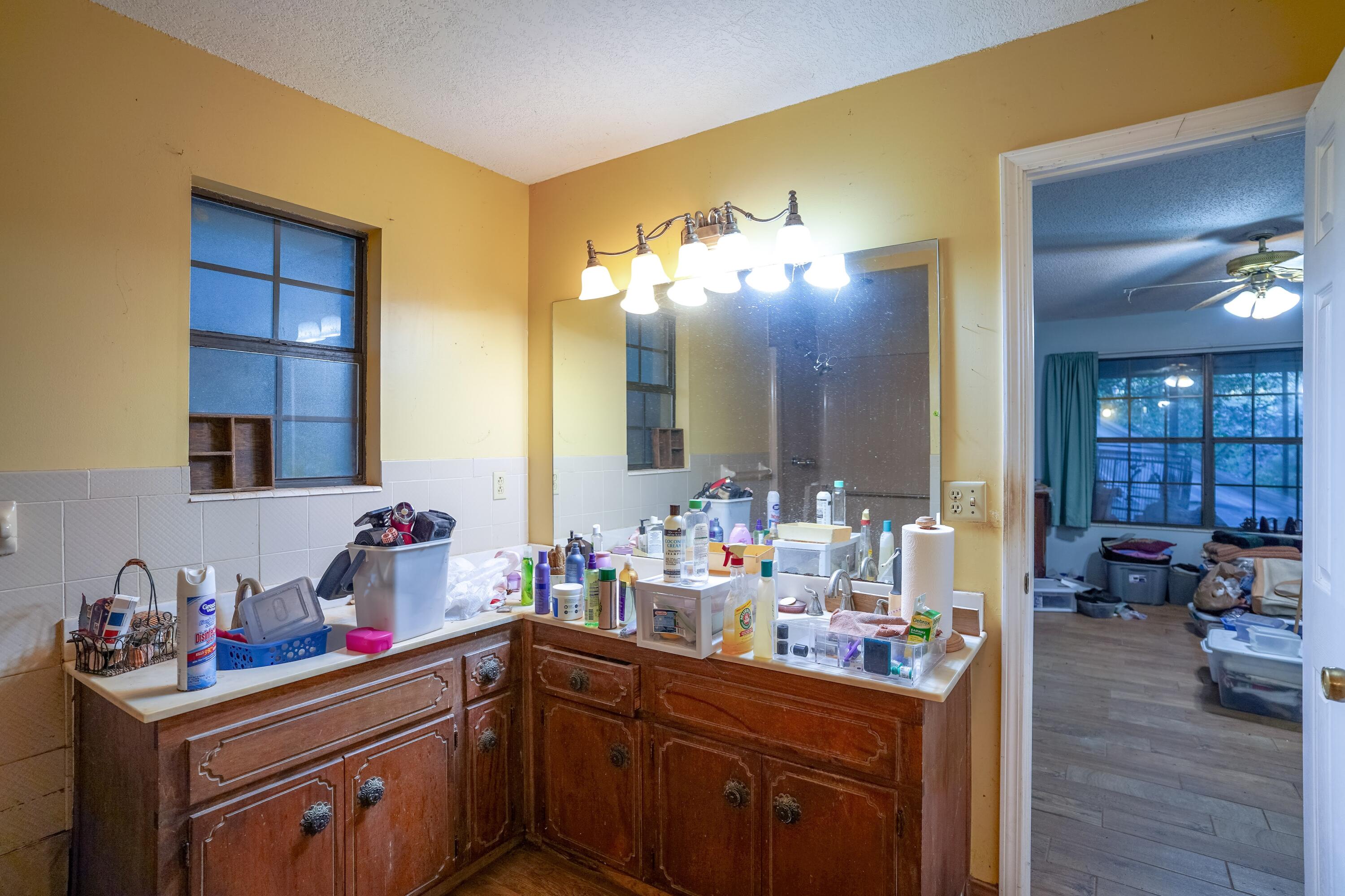 4444 Sundance Way Holt, FL 32564 - Photo 28 of 39 a kitchen with a sink cabinets and wooden floor