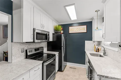 a kitchen with stainless steel appliances granite countertop a sink stove microwave and refrigerator