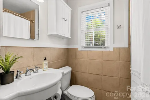 a bathroom with a sink a toilet and mirror