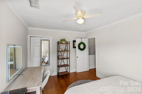 a bedroom with a bed and painting on the wall