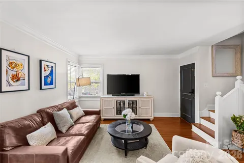 a living room with furniture a flat screen tv and a large window