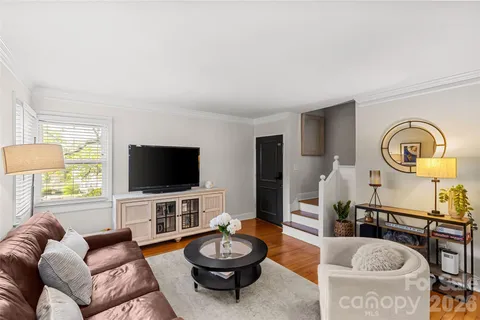 a living room with furniture a flat screen tv and a large window