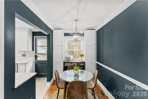 a dining room with furniture a chandelier and wooden floor