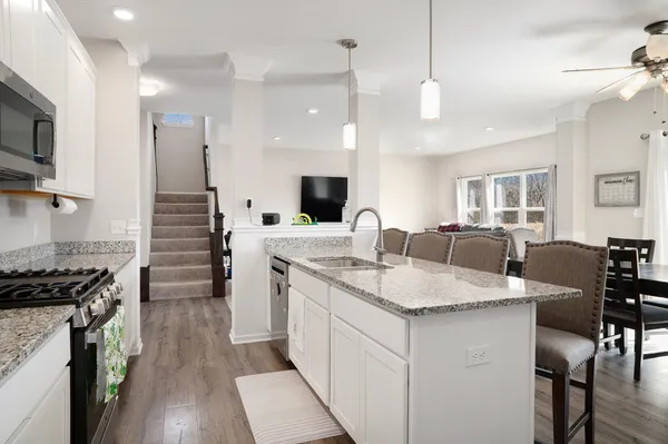 a kitchen with granite countertop a sink a counter space appliances and cabinets