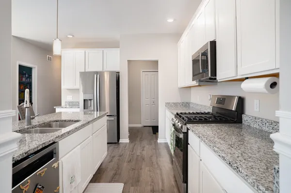a kitchen with stainless steel appliances granite countertop a sink stove and refrigerator