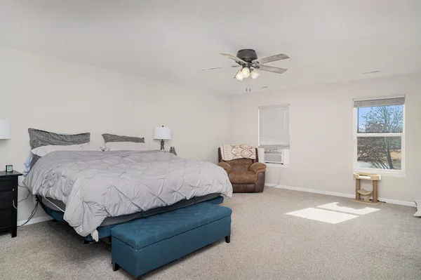 a spacious bedroom with a bed and window