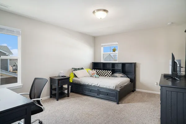 a bedroom with a bed a desk and chair