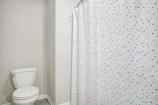 a a bathroom with a toilet and a shower curtain