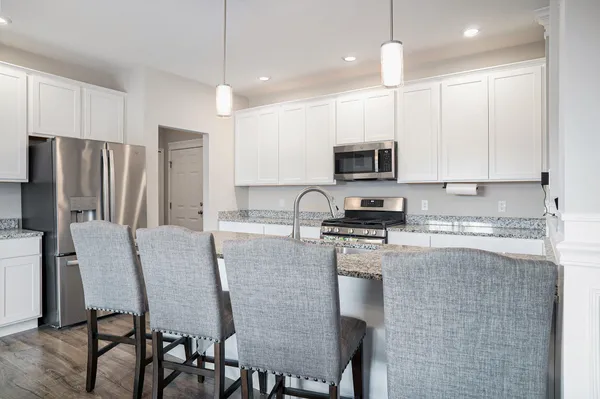 a kitchen with stainless steel appliances granite countertop a stove top oven a refrigerator a sink and a microwave