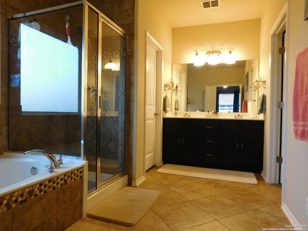 9626 Common Law Converse, TX 78109 - Photo 19 of 31 a bathroom with a tub a sink and mirror