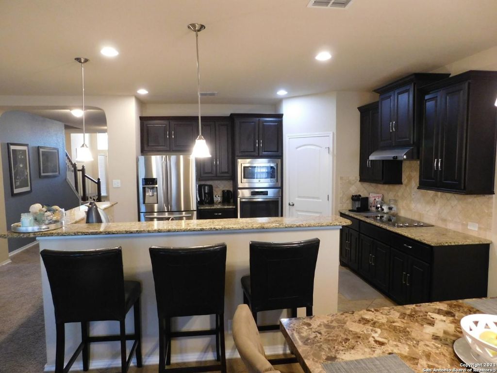 9626 Common Law Converse, TX 78109 - Photo 5 of 31 a kitchen with stainless steel appliances kitchen island granite countertop a sink and cabinets