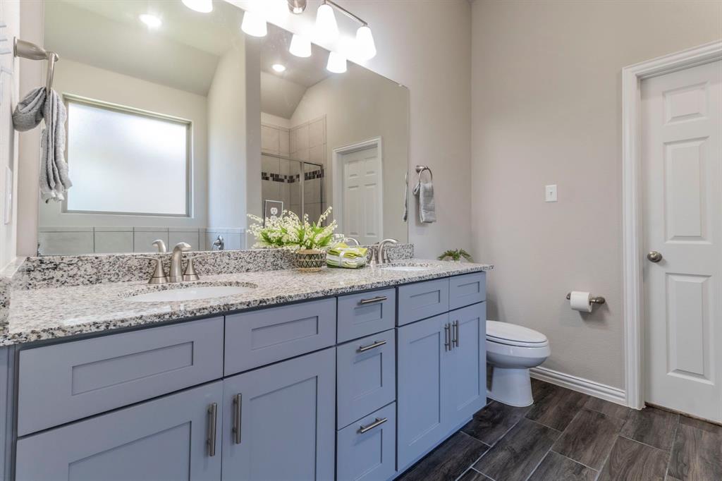626 Ruthye Lane Pilot Point, TX 76258 - Photo 10 of 27 Primary bathroom with double vanity, a shower stall, and wood-look tile floors
