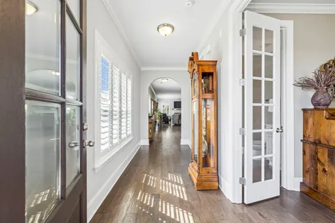 a view of a dining room with furniture a chandelier and wooden floor
