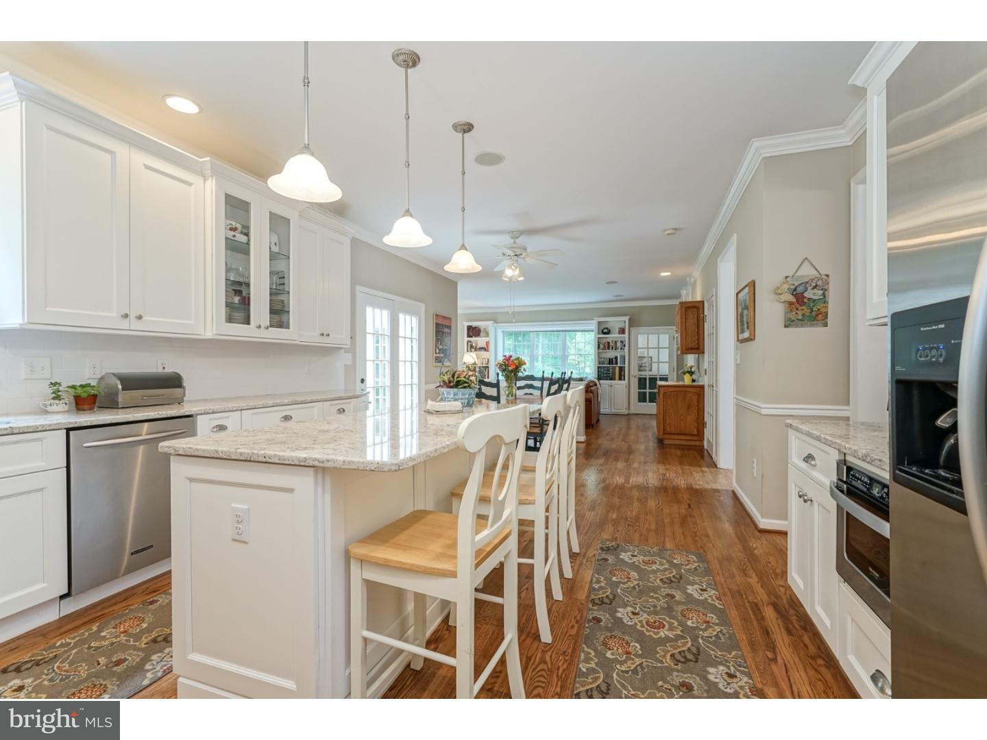 38 Stanwyck Road Mount Laurel, NJ 08054 - Photo 12 of 25 a kitchen with stainless steel appliances kitchen island granite countertop a stove top oven a sink a dining table and chairs with white cabinets