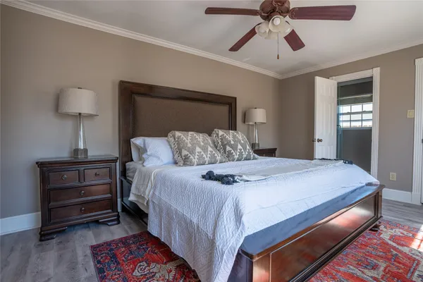 a bedroom with a bed and a lamp on dresser