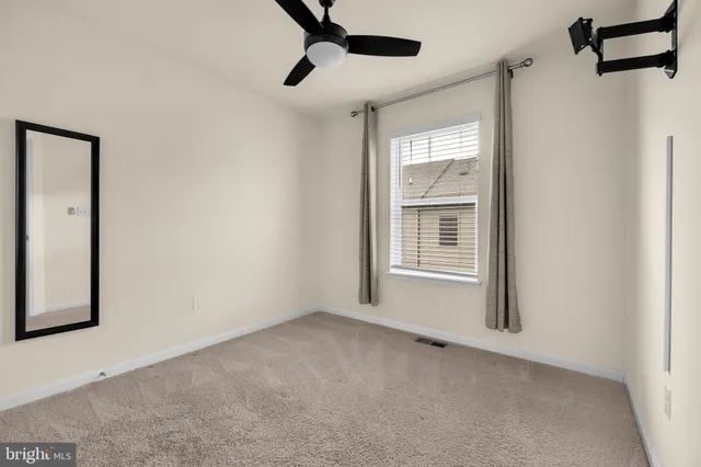 a view of a room with a ceiling fan and windows