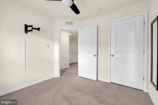 an empty room with closet and windows