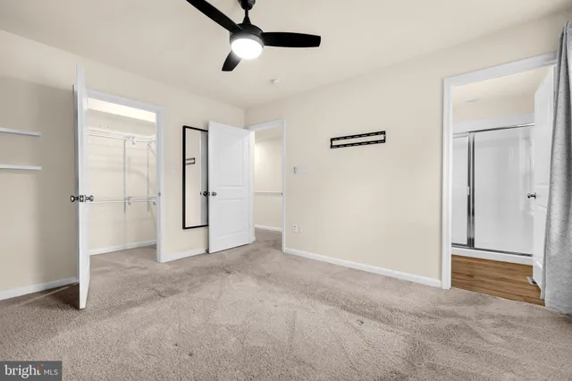 an empty room with closet and a ceiling fan