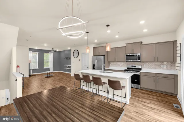 a large kitchen with kitchen island a sink table and chairs