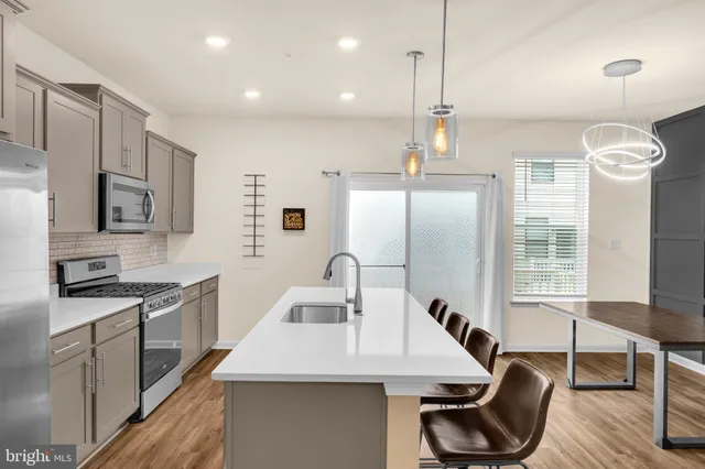 a kitchen with stainless steel appliances granite countertop a sink a stove and a refrigerator