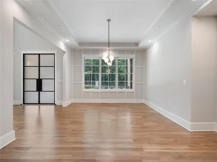 a large white kitchen with kitchen island a sink dishwasher a refrigerator and a fireplace with wooden floor