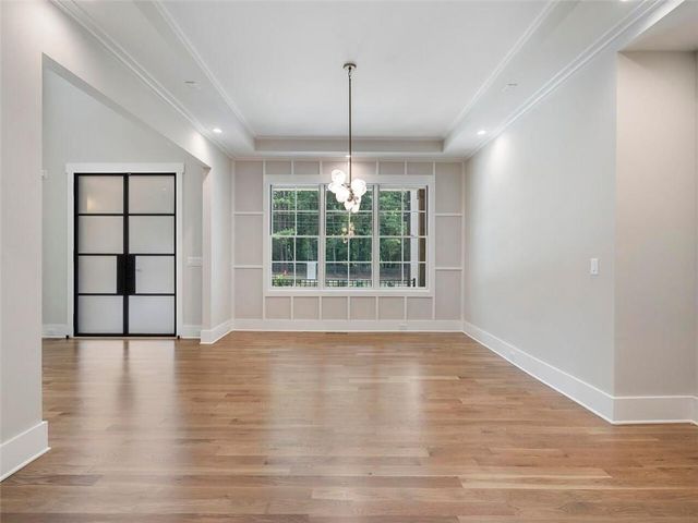 a large white kitchen with kitchen island a sink dishwasher a refrigerator and a fireplace with wooden floor