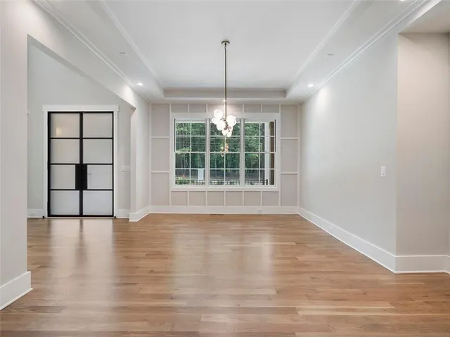 a large white kitchen with kitchen island a sink dishwasher a refrigerator and a fireplace with wooden floor