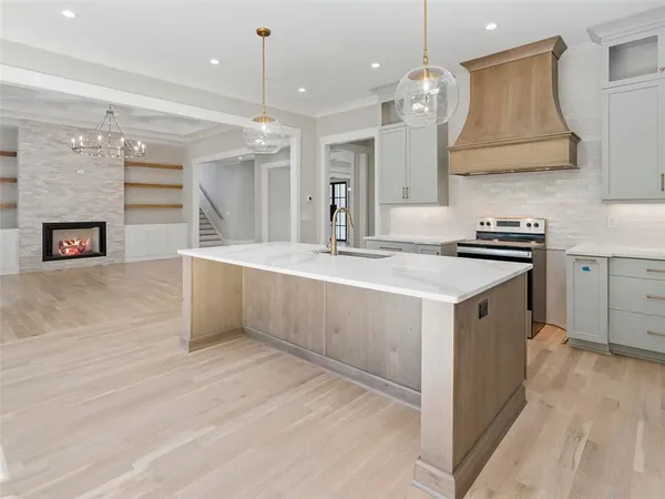 a large kitchen with stainless steel appliances granite countertop a stove and a large window