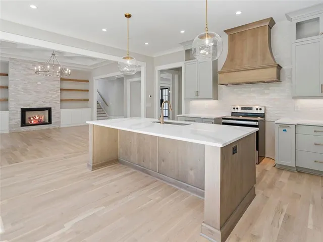 a large kitchen with stainless steel appliances granite countertop a stove and a large window