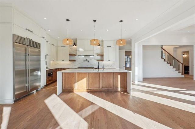 a kitchen with stainless steel appliances granite countertop a sink a stove and a refrigerator