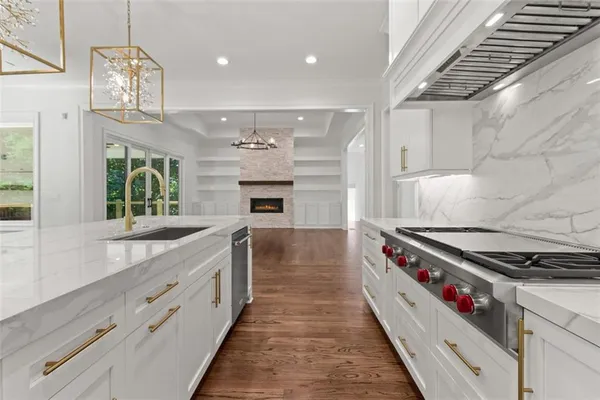 a kitchen with granite countertop cabinets stainless steel appliances and wooden floor