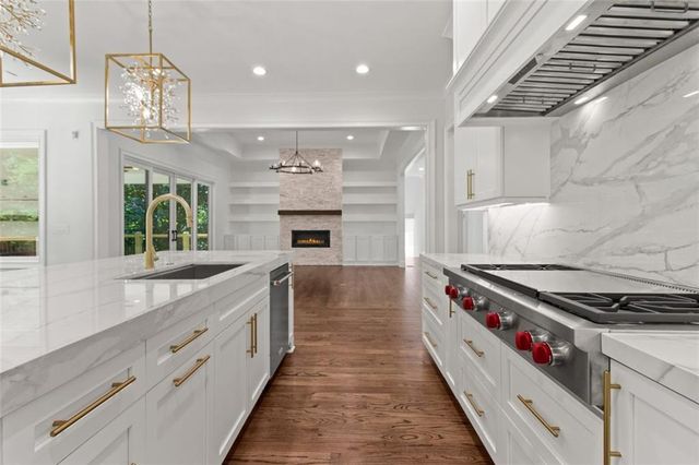 a kitchen with granite countertop cabinets stainless steel appliances and wooden floor
