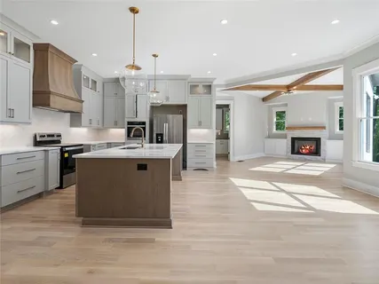 a kitchen with stainless steel appliances a sink and wooden floor