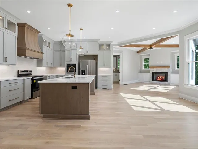 a kitchen with stainless steel appliances a sink and wooden floor