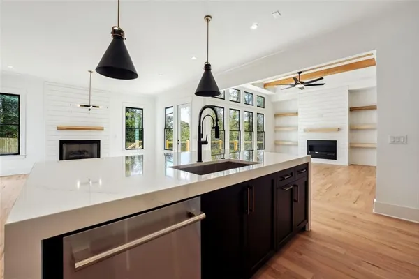 a kitchen with granite countertop a stove and a wooden floor