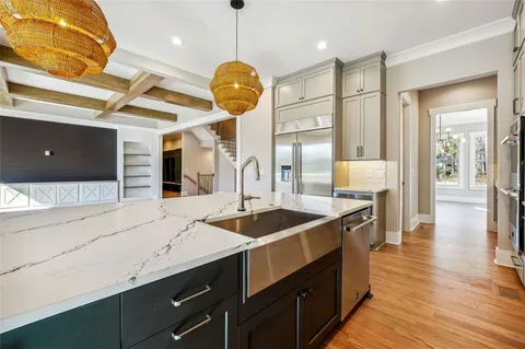 a view of an empty room with wooden floor and windows