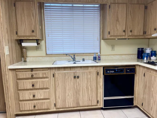 a kitchen with white cabinets and appliances