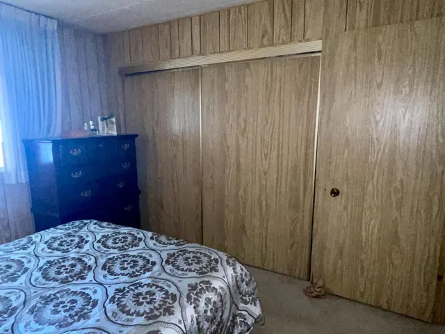 a spacious bedroom with a bed a couch and a chandelier