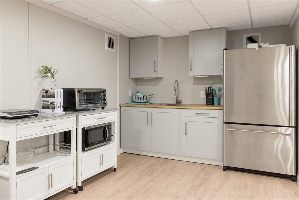 38 Maple Street, Unit 38 Needham, MA 02492 - Photo 11 of 14 a kitchen with white cabinets and white appliances
