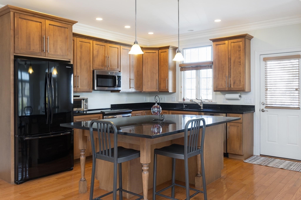 38 Maple Street, Unit 38 Needham, MA 02492 - Photo 4 of 14 a kitchen with granite countertop a refrigerator stove top oven a sink and dishwasher