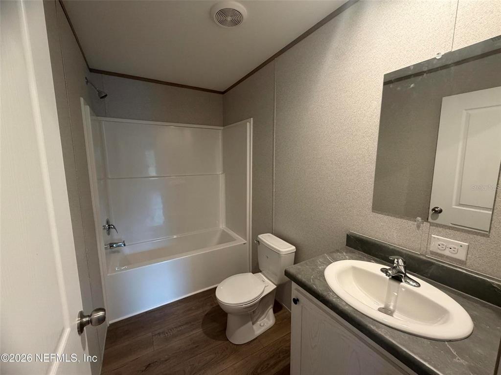 114 Nutmeg Trail Interlachen, FL 32148 - Photo 24 of 33 a bathroom with a granite countertop sink toilet a mirror and shower