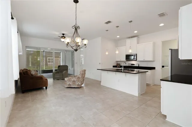 a living room with kitchen island furniture and a chandelier