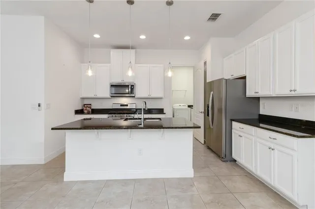 a kitchen with stainless steel appliances granite countertop a sink and a refrigerator