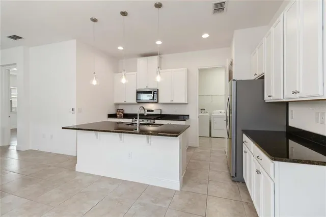 a kitchen with stainless steel appliances granite countertop a sink and cabinets