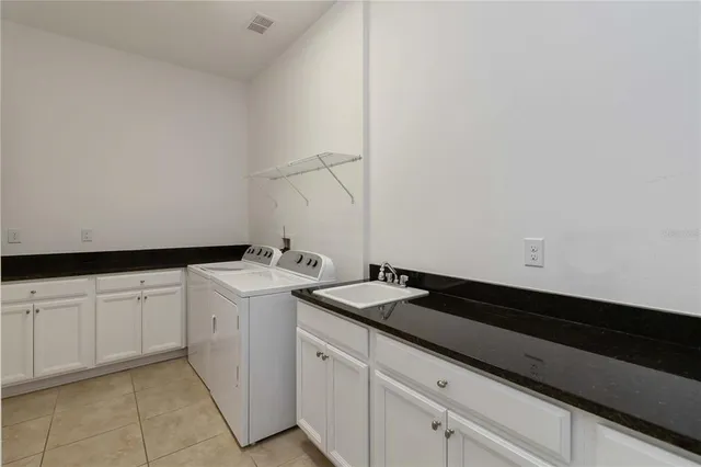 a utility room with sink dryer and washer